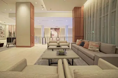 a living room with two couches and a table at AC Hotel by Marriott Fort Lauderdale Airport in Dania Beach