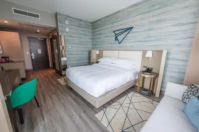 a bedroom with a large bed and a couch at Marriott Fort Lauderdale Airport in Dania Beach