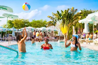 three women playing with a volley ball in a swimming pool at The Goodtime Hotel, Miami Beach a Tribute Portfolio Hotel in Miami Beach