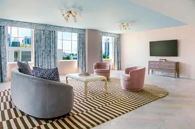 a living room with two chairs and a television at The Goodtime Hotel, Miami Beach a Tribute Portfolio Hotel in Miami Beach
