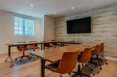a conference room with tables and chairs and a flat screen tv at Iberostar Waves Miami Beach in Miami Beach