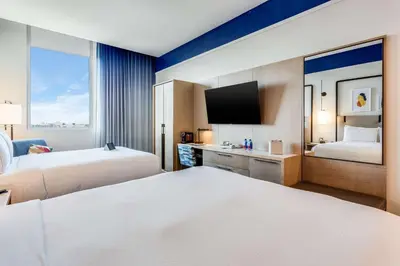 a hotel room with two beds and a tv at SERENA Hotel Aventura Miami, Tapestry Collection by Hilton in Aventura