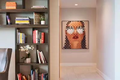 a painting of a woman on a wall next to a book shelf at SERENA Hotel Aventura Miami, Tapestry Collection by Hilton in Aventura