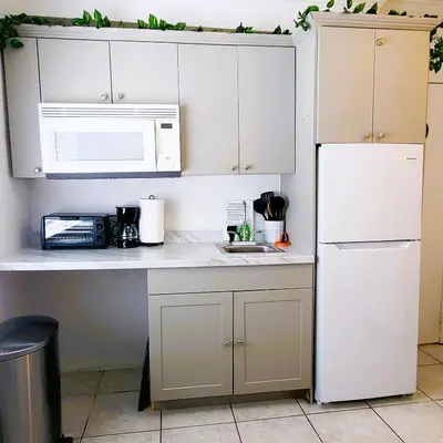 a kitchen with white cabinets and a white refrigerator at OCEAN FRONT BEACH PADS---South Beach in Miami Beach