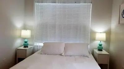 a bedroom with a large window with a bed and two lamps at SOBE SUNSHINE ONE BEDROOM APARTMENTs in Miami Beach