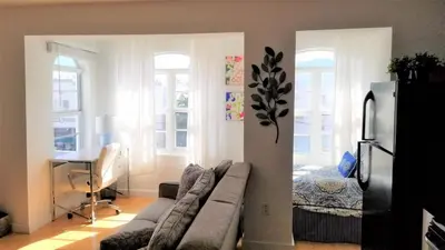 a living room with a couch and a bed at SOBE SUNSHINE ONE BEDROOM APARTMENTs in Miami Beach