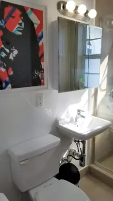 a bathroom with a white toilet and a sink at SOBE SUNSHINE ONE BEDROOM APARTMENTs in Miami Beach