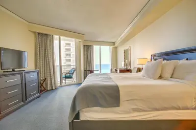 a bedroom with a large bed and a large window at Pool and Tennis Beachfront Florida Condo! in Miami Beach