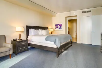 a bedroom with a bed and a chair and a couch at Pool and Tennis Beachfront Florida Condo! in Miami Beach