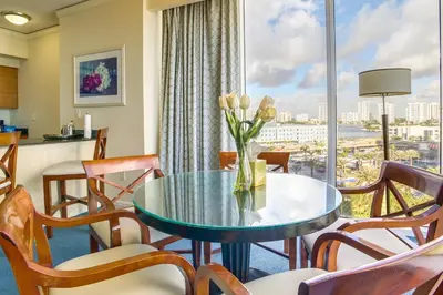 a dining room with a table and chairs and a large window at Pool and Tennis Beachfront Florida Condo! in Miami Beach