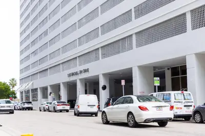 a large white building with cars parked in front of it at Modern and Luxurious Brickell Studio in Miami