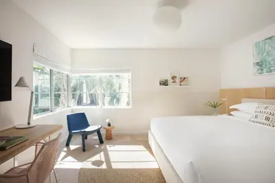 a bedroom with a bed and a desk and a chair at The Kimpton Shorebreak Fort Lauderdale Beach Resort in Fort Lauderdale