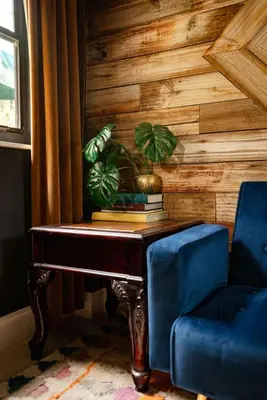 a blue chair and a table with a plant on it at The Rum Locker - 1 King - 2 Twins - Private home and Patio - Sleeps 4 in Fort Lauderdale