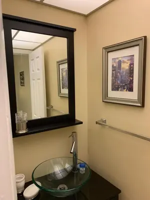 a bathroom with a glass sink and a mirror at Walk to the Beach at Sunny Isles in Miami Beach