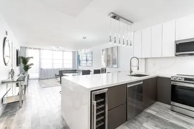 a kitchen with white cabinets and a large island at AMAZING 2BR 2BA NEWLY RENO BEACHFRONT APT W/BEACH VIEW in Hollywood