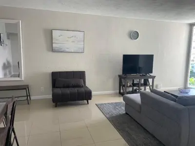 a living room with a couch and a chair at Spacious 1BR on the Beach, The Tides, Hollywood,FL in Hollywood