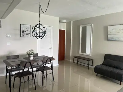 a dining room with a table and chairs and a couch at Spacious 1BR on the Beach, The Tides, Hollywood,FL in Hollywood