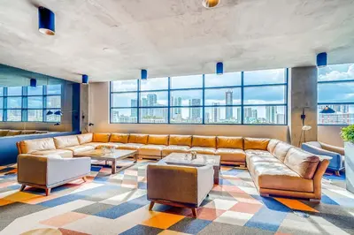 a living room with a couch and a large window at Sentral Wynwood in Miami