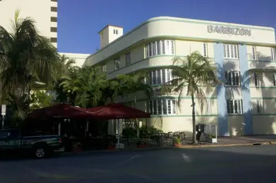 a large white building with palm trees in front of it at *530 BEACH PAD-OCEAN DRIVE* in Miami Beach