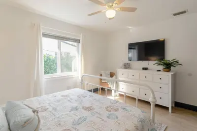 a bedroom with a bed and a dresser with a television at Casa Madeira 2@ the heart of Miami Design District in Miami