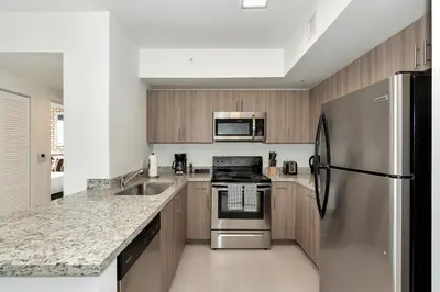 a kitchen with a stainless steel refrigerator and a sink at Roami at Grove 27 in Miami