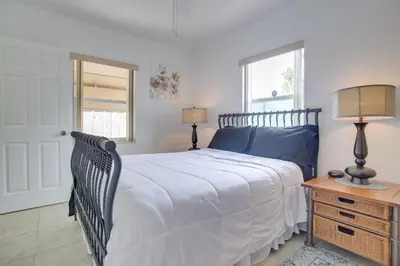 a bedroom with a bed and a table with two lamps at 2 Mi to Boardwalk Home with Grill in Dania Beach! in Dania Beach