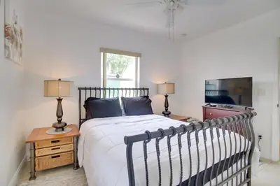 a bedroom with a bed and a table with two lamps at 2 Mi to Boardwalk Home with Grill in Dania Beach! in Dania Beach