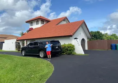 a man standing in front of a car in front of a house at Spanish Style House - Free Parking in Miami