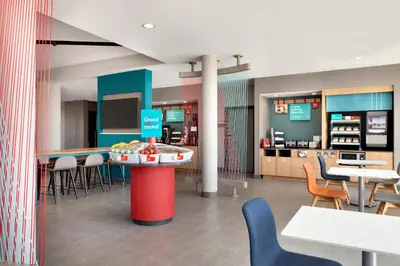 a restaurant with tables and chairs and a counter at avid hotel - Ft Lauderdale Airport - Cruise by IHG in Fort Lauderdale