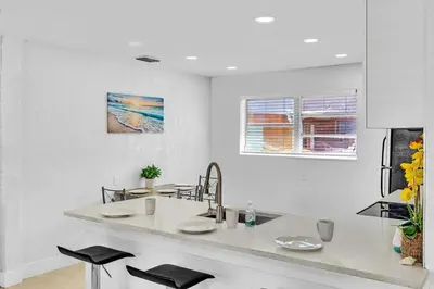 a white kitchen with a counter and a sink at Modern 2br Near Aventura Mall & Sunny Beach in Hallandale Beach
