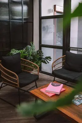 a room with two chairs and a table with a book at Upsun Hotel in Miami Beach