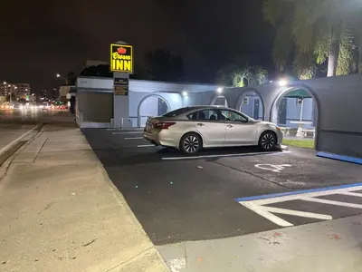 a silver car parked in a parking lot at night at Crown Inn in Fort Lauderdale