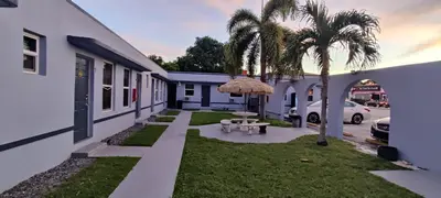 a yard with a table and a palm tree at Crown Inn in Fort Lauderdale