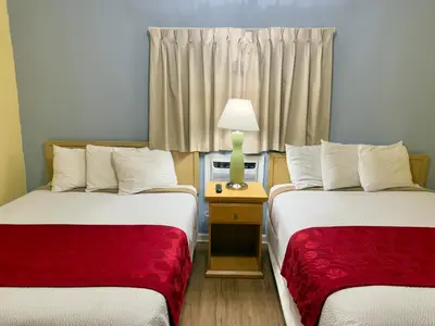 a room with two beds and a lamp on a table at Crown Inn in Fort Lauderdale