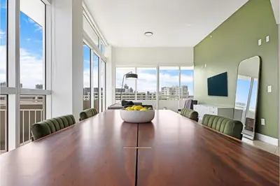a dining room with a large table with a bowl of fruit on it at Roami at Sunny Isles in Miami Beach