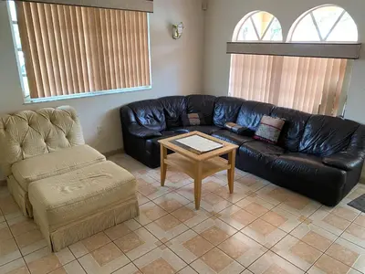 a living room with a leather couch and a coffee table at Private Cubicle - Single Bed - Mixed Shared Dorm - MIAMI AIRPORT in Miami