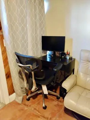 a computer desk with a monitor and a chair at Cozy apartment in quite zone in Hollywood