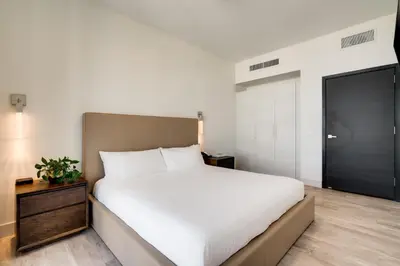a bedroom with a white bed and a black door at Costa Hollywood Beach Resort - An All Suite Hotel in Hollywood