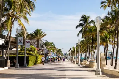a sidewalk lined with palm trees next to the beach at Costa Hollywood Beach Resort - An All Suite Hotel in Hollywood