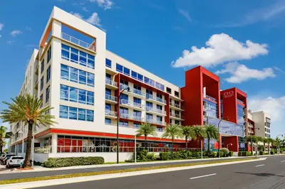an apartment building on a street with palm trees at Costa Hollywood Beach Resort - An All Suite Hotel in Hollywood