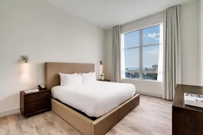 a bedroom with a bed and a large window at Costa Hollywood Beach Resort - An All Suite Hotel in Hollywood