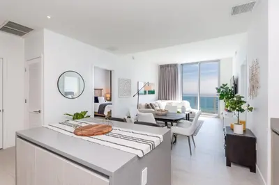 a white room with a large bed and a living room at Hyde Beach House Luxury Condo-Resort condo in Hollywood Beach