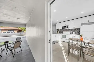 a kitchen and dining room with a table and chairs at 2 Bdrm Modern House Mins From Beach & Casino Hb1 in Hallandale Beach