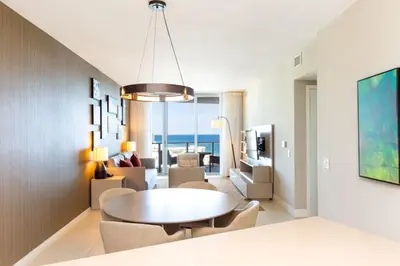 a living room with a table and a living room with the ocean at HYDEOV1BR - Unit 1910 - Ammos condo in Hollywood Beach