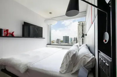 a bedroom with a large white bed and a window at citizenM Miami Brickell in Miami