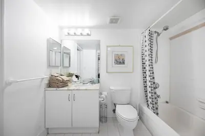 a white bathroom with a toilet and a tub and a sink at Private Unit Miami With Amenities And Parking in Miami