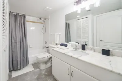 a white bathroom with a toilet and a sink at Spectacular apartment in Heart of Brickell in Miami