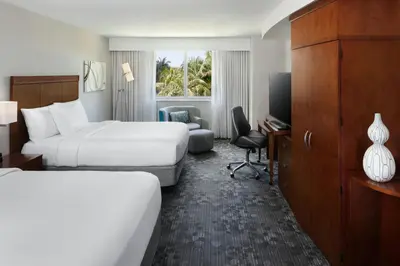 a hotel room with two beds and a television at Courtyard by Marriott Miami Airport in Miami