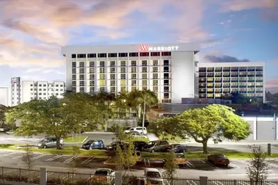 a large hotel with cars parked in a parking lot at Courtyard by Marriott Miami Airport in Miami