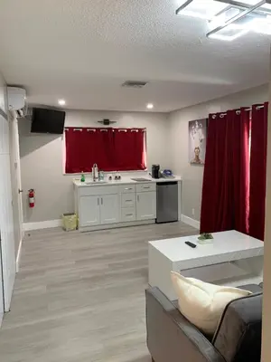 a living room with red curtains and a kitchen at The Tel in Hollywood